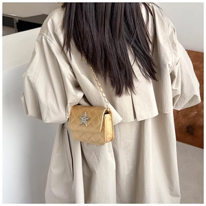 Detailed back view of a gold quilted mini bag with star-shaped crystal buckle and chain strap