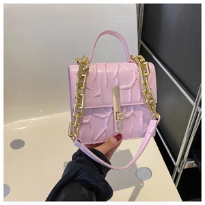 Detailed view of pink shoulder bag with embossed branch texture and gold chain strap