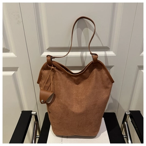 Detailed macro view of brown frosted suede tote bag showing texture and small side pouch