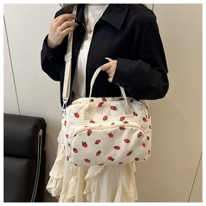 Close-up of a large-capacity strawberry print corduroy shoulder bag for women's travel.