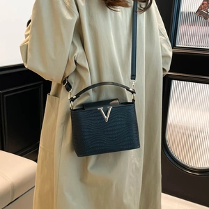 Sac à main noir minimaliste avec motif ondulé, logo V doré et bandoulière réglable