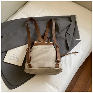 Dettaglio dello zaino vintage in tela con cinghie in pelle marrone e chiusura a cordoncino