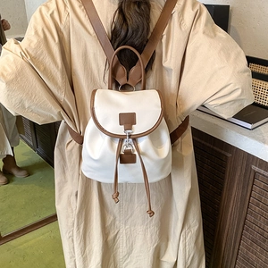 Zaino vintage in ecopelle color crema con profili marrone scuro indossato da modella