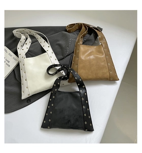 Détails des sacs fourre-tout en blanc, marron et noir avec des œillets métalliques