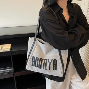 Minimalist canvas tote bag with black leather trim and HOORYA logo for daily commute