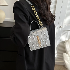 Silver square shoulder bag with branch relief texture and gold chain strap in modern setting
