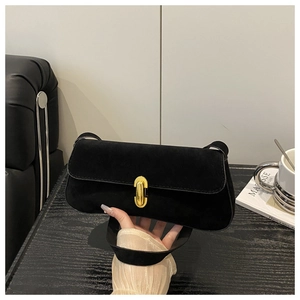 Detailed view of black suede underarm bag with an elegant oval gold metal buckle closure