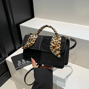 Fashionable black square crossbody bag with leopard print panel and silk scarf handle