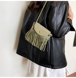 Detail of green suede fringe crossbody bag with flap cover and long tassels