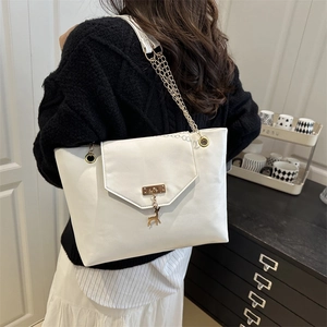 Chic white PU leather tote bag with gold chain strap and deer pendant shown on a model