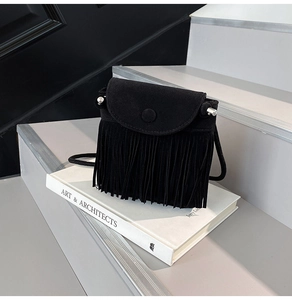 Detail of black fringe crossbody bag with suede texture and metallic ball accents
