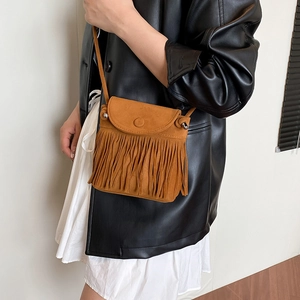 Brown vintage bohemian tassel crossbody bag styled with a leather jacket and white dress