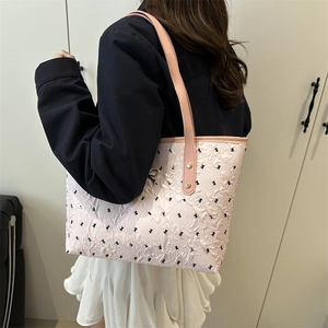 Sac fourre-tout rose matelassé avec broderie de nœuds noirs et rivets dorés