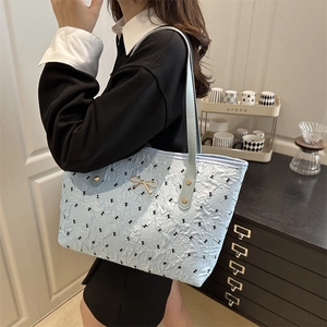 Sac cabas bleu clair à texture bulle avec imprimés nœuds et boucle dorée en métal