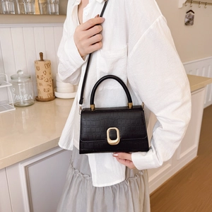 Elegant black crocodile-textured handbag with gold buckle and adjustable strap