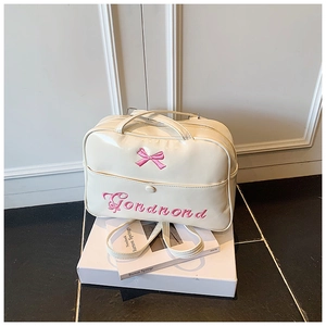 Dettaglio borsa da viaggio in pelle PU crema con ricamo a fiocco rosa e tasca frontale