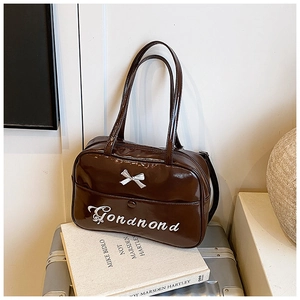 Dettaglio borsa da viaggio in pelle verniciata testa di moro con fiocco e ricamo GONDNOND