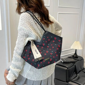 Minimalist black tote bag with red cherry print and decorative ribbon for women