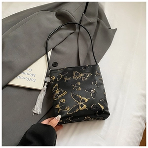 Ricamo dettagliato di farfalle dorate su borsa in raso nero con nappa argentata