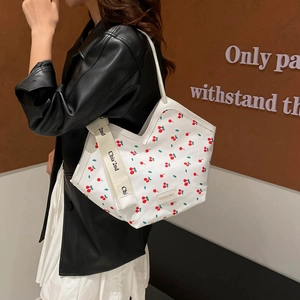 Minimalist white canvas tote bag with red cherry print and wide shoulder straps