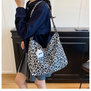 Détail du sac cabas en toile léopard avec large bandoulière et pendentif en peluche doux