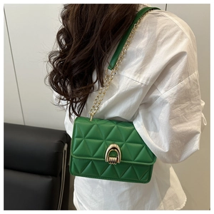 Détail du sac à bandoulière vert matelassé avec fermoir doré et bandoulière chaîne