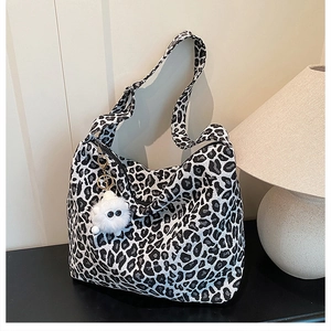 Gros plan du sac fourre-tout léopard tricoté avec fermeture éclair et breloque peluche