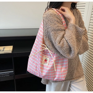 Detail of pink and blue checkered canvas tote bag with drawstring and handmade fabric label