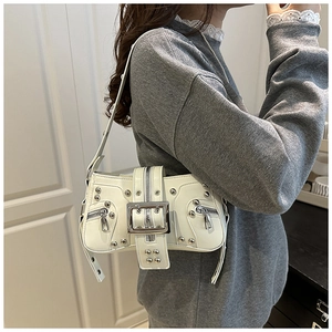 Close-up of cream Y2K shoulder bag featuring silver rivets and large metal buckle detail