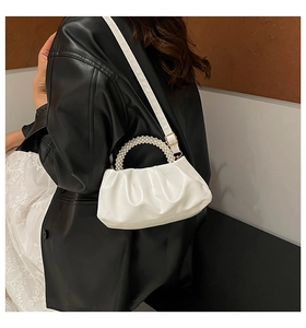 Detail showing the white pleated cloud bag with elegant pearl beaded handle and texture