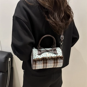 Sac Boston vintage chic à motifs d'étoiles avec détail de nœud marron porté par un modèle
