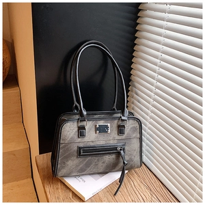 Close-up of vintage grey shoulder bag with tassel zipper and refined metal hardware