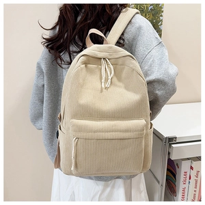Detail view of cream corduroy backpack featuring front pocket and wide padded shoulder straps