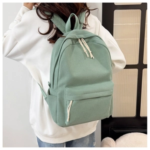 Close-up detail of light green striped corduroy casual backpack with woven zipper pulls