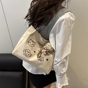 Chic off-white canvas tote bag with cat print and plush pendant for daily commute