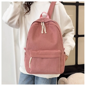 Detail of pink corduroy backpack featuring side pockets and textured fabric surface