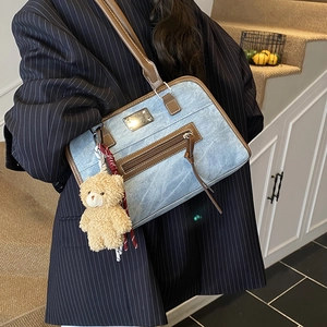 Vintage denim underarm bag with brown leather trim and cute plush bear pendant