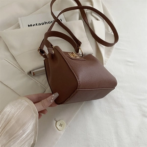 Détail du sac à main marron à motif litchi avec son fermoir rotatif doré élégant