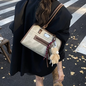 Retro grey-green tote bag with brown leather trim and cute bear charm shown outdoors