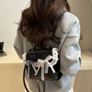 Black PU leather ballet style mini backpack with lace trim and bows worn by a model