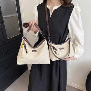 Schickes Set aus beiger Canvas-Tasche mit braunem Lederbesatz und bunten Perlen