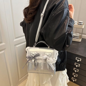 Silver metallic student backpack with black ribbon bow and white lace trim detail