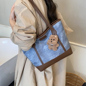 Borsa tote in denim blu con finiture in pelle marrone e ciondolo a forma di orso