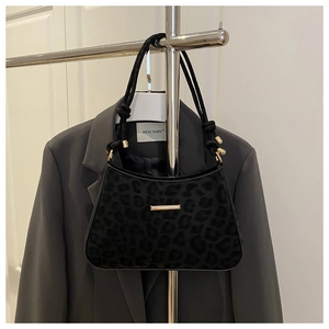 Détail de la texture léopard sur un grand sac porté épaule noir avec finitions dorées