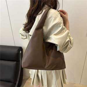 Brown textured leather large tote bag shown on model for professional commuting style