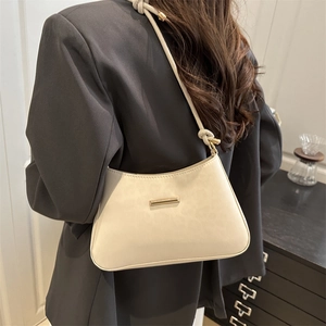 Sac à bandoulière baguette beige minimaliste avec bandoulière nouée et détails dorés