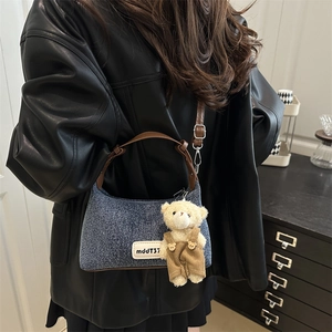 Retro denim shoulder bag in blue with brown leather straps and a cute teddy bear charm