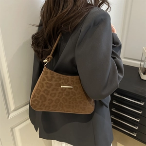 Sac à bandoulière léopard rétro avec garniture dorée porté sur un blazer gris