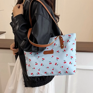 Chic light blue tote bag with cherry print and leather straps for casual daily use
