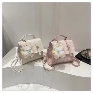 Close-up of cream and pink plaid mini backpacks with cute plush bear charms